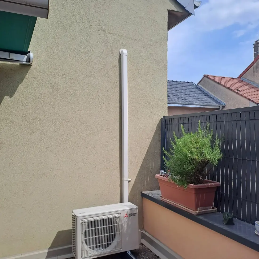 Groupe extérieur en terrasse avec sa goulotte de liaison verticale posée bien droite sur la façade